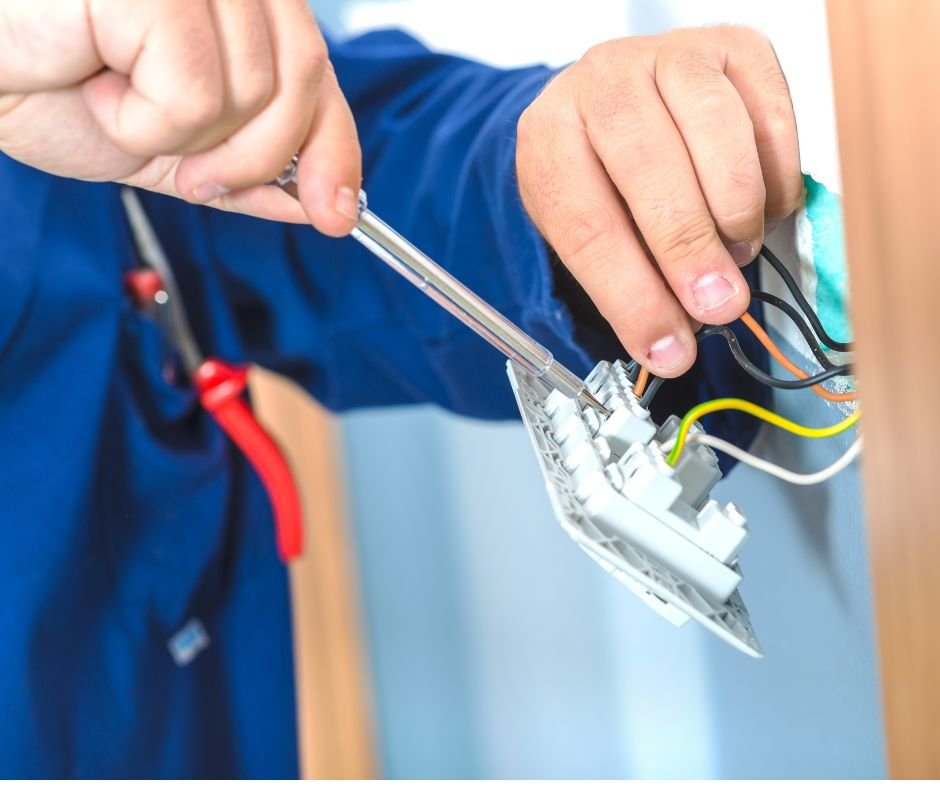 Elektriker mit Schraubenzieher beim Anschluss einer Steckdose